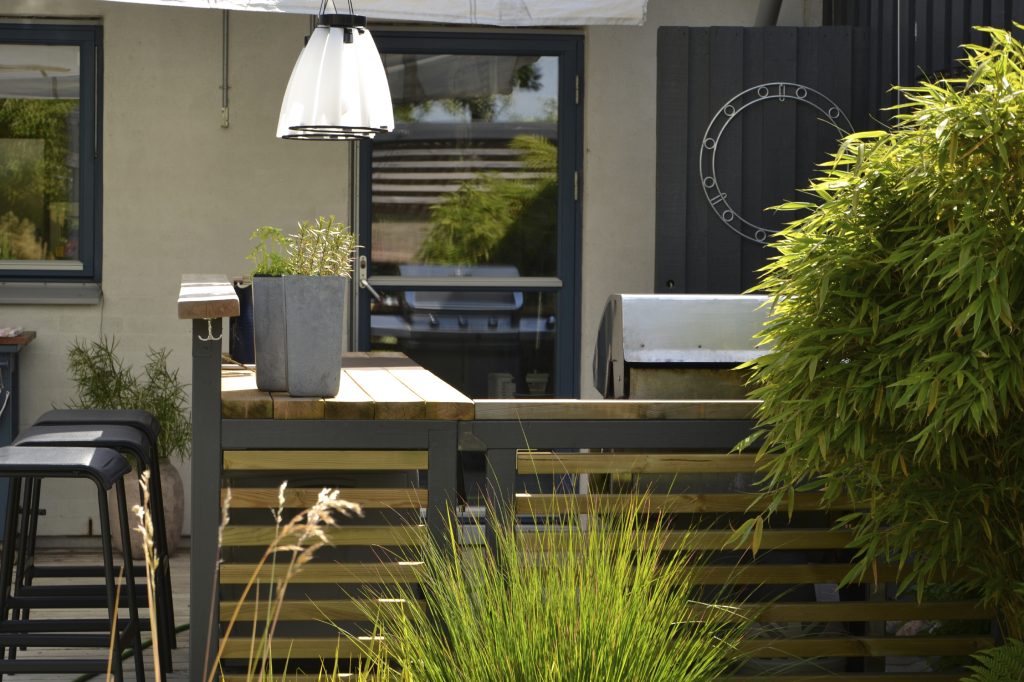 An outdoor kitchen and dining area during the summer