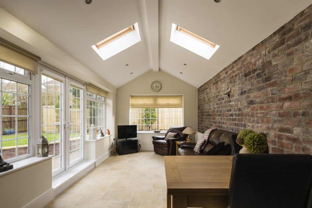 Modern Sunroom or conservatory extending into the garden with a featured brick wall