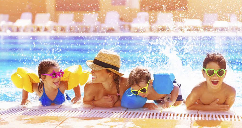 Family enjoying summer fun at home and in the pool