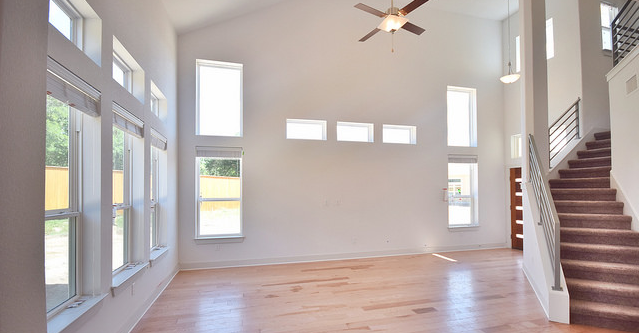 A spacious floor plan with an entry into a living room with staircase.