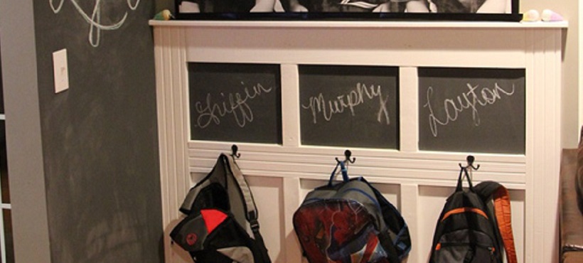 Backpacks on hooks with chalkboards above in back-to-school-ready home.