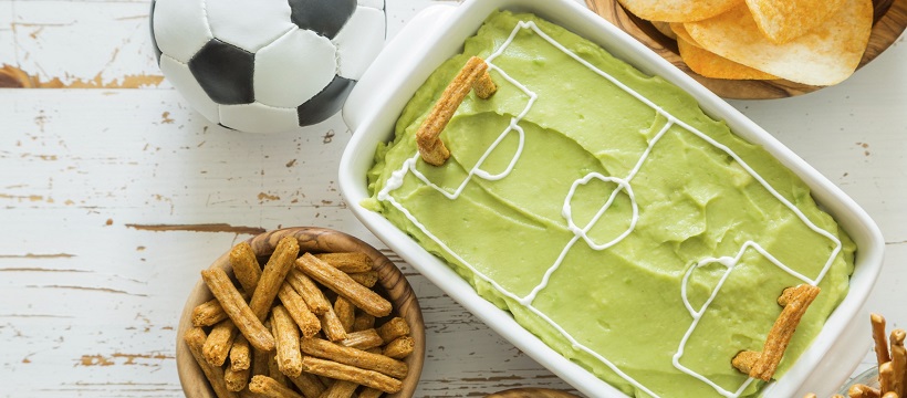 Guacamole and pretzels set out for a game-day party.