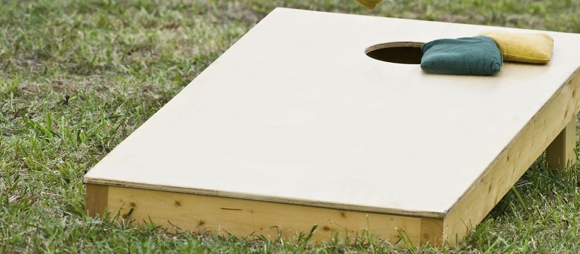 Bean bag toss game set outside for a game-day party.