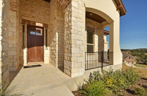 View of stone exterior and hill country from front porch of West Cypress Hills home.