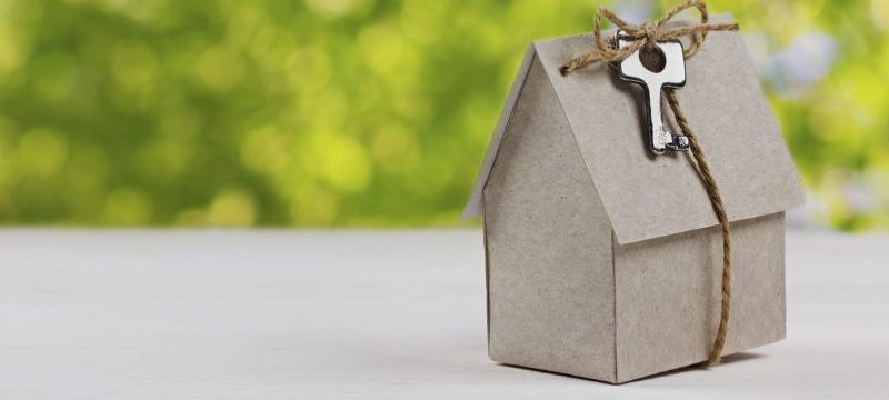 Cardboard home model wrapped in keys to new home.