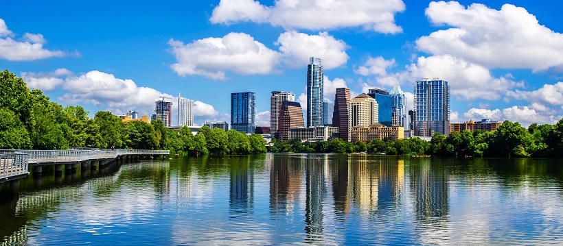 Blue skies and water surrounding Austin, Texas skyline.