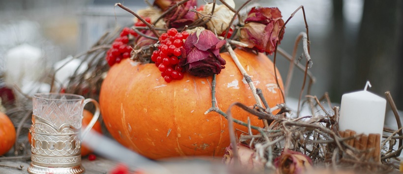 Rustic sticks and candles around a pumpkin for Halloween home décor ideas