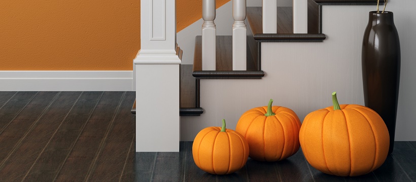 Pumpkins and vase next to staircase on the floor
