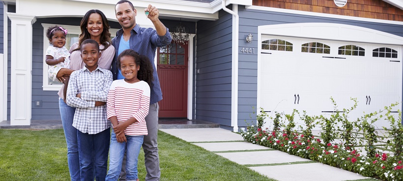 Family outside of new home as the dad holds keys in his hand