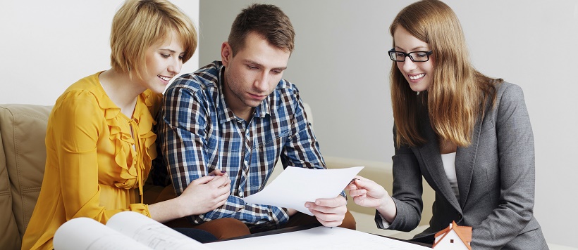 Couple meeting with real estate agent to discuss when to buy a home