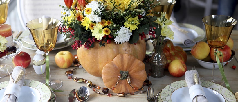 Pumpkin filled with flowers as a centerpiece for Thanksgiving table decor