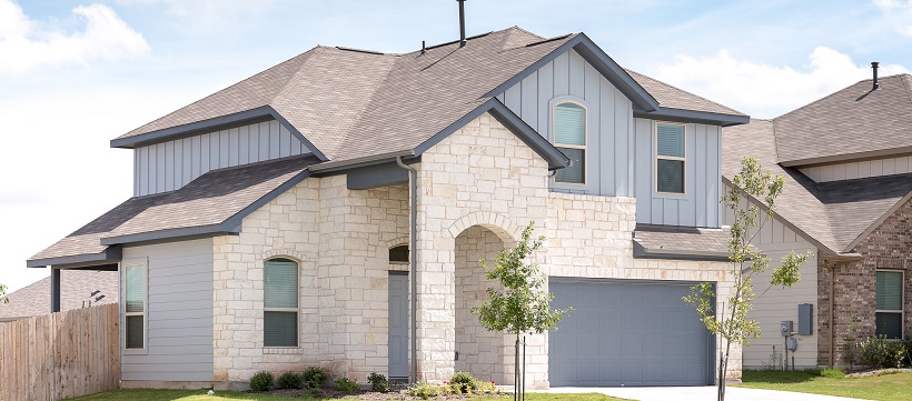 Stone and blue painted exterior of one of the inventory homes in Austin, Texas