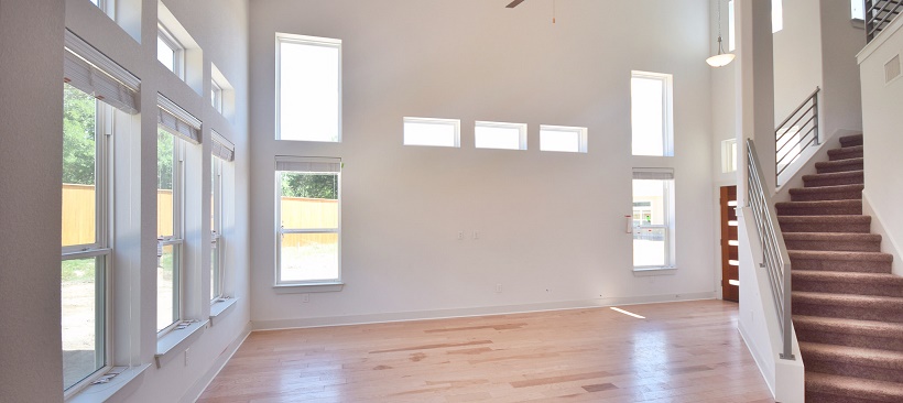 Living room of a move-in ready home with windows and hardwood flooring