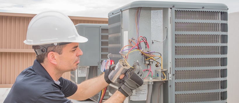 Man working on HVAC for a home winterization plan