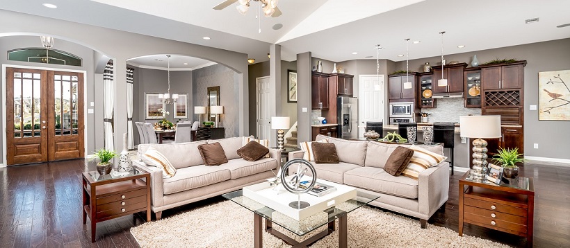 Brown and white living room centered around dining room and kitchen in a new Austin home