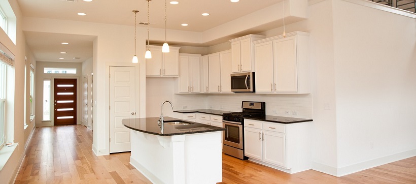 Modern white kitchen with black countertops in a new Austin home