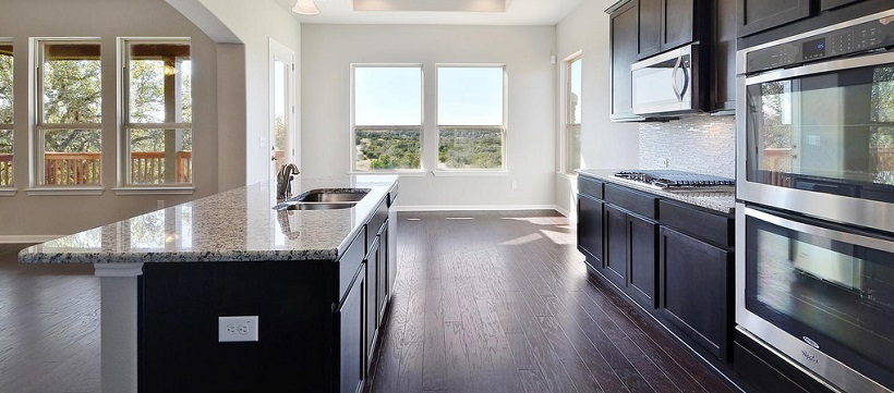 Kitchen with granite countertops, dark brown cabinetry and a Hill Country view