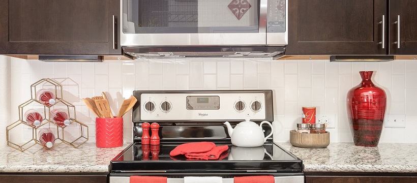 A new Austin home kitchen with brown cabinetry and red décor 