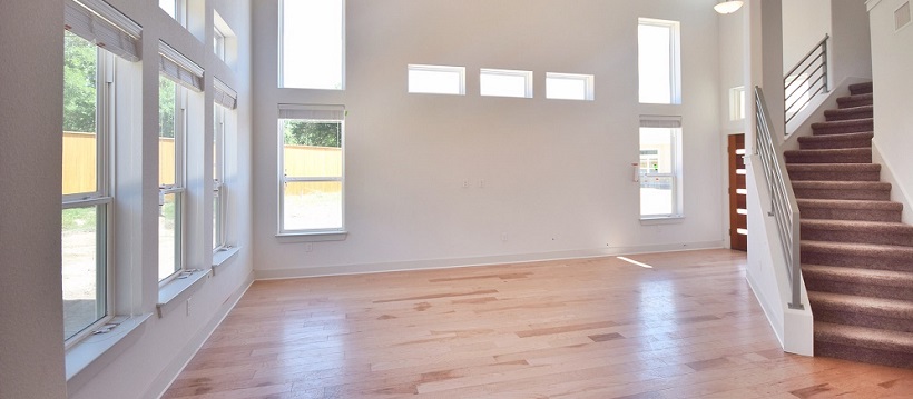 Modern living room with hickory hardwood floors below rectangular windows 