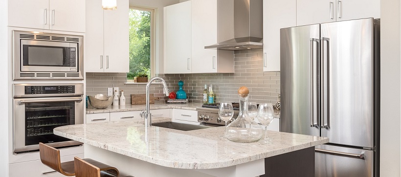 Modern kitchen with white cabinetry, white granite and stainless steel appliances