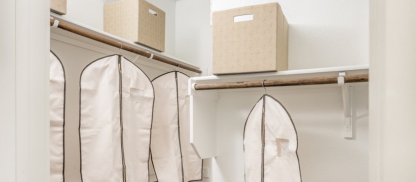 A new Austin home’s walk-in closet with storage boxes and clothing bags