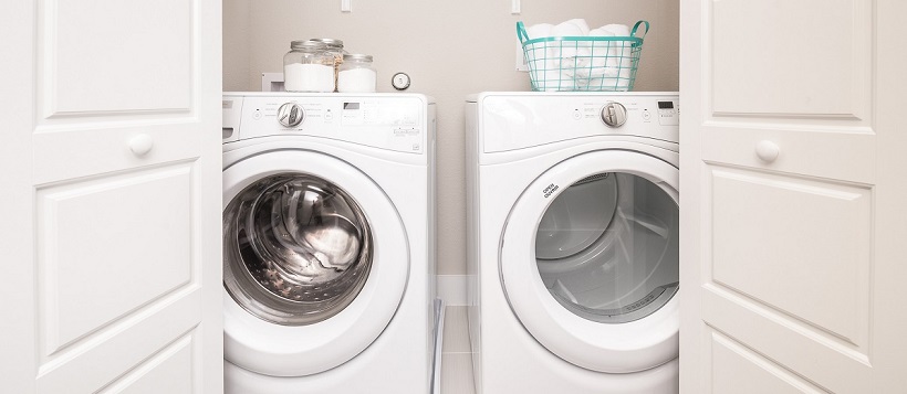 Doors opening to washer and dryer of a laundry home in a new Austin home