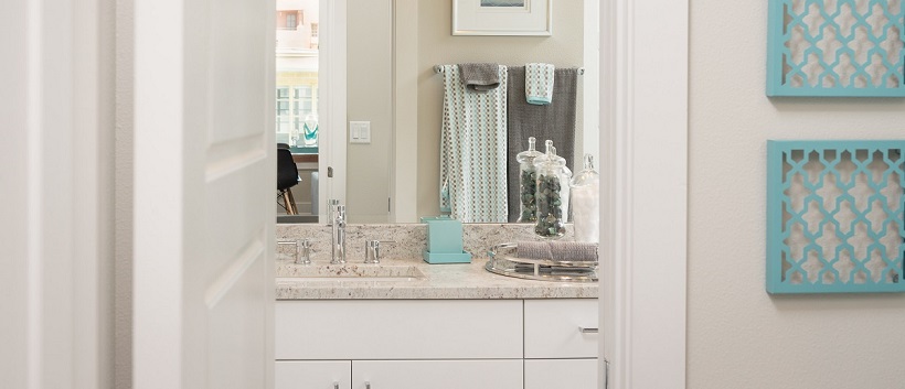 Looking into a contemporary white bathroom from the hallway of a new Austin home