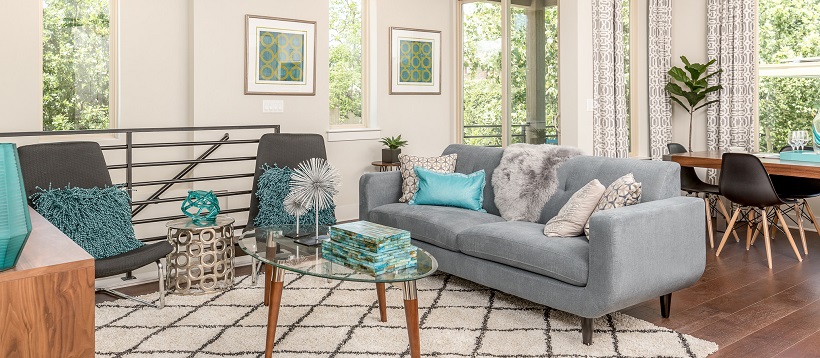 Modern white living room with gray furniture and blue shades of pillow and home decor.