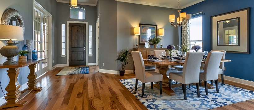 Entryway and dining room with hardwood floor and blue accent wall and decor.