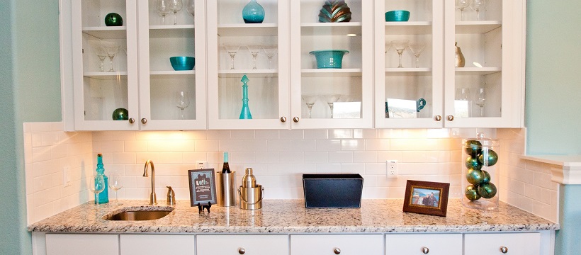 Light blue walls surround white cabinetry with glass covers showing blue home decor ideas inside each cabinet.