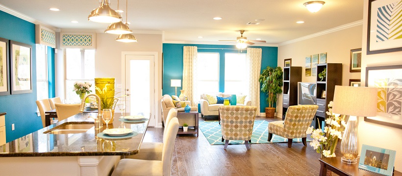 Bright blue accent walls in connected dining room and living room offer great blue home decor ideas.