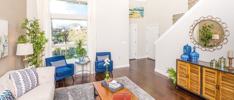 White living room and entryway with bright navy blue accent pieces including armchairs, pillows, and decor pieces.