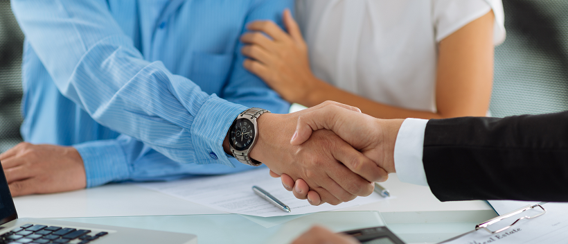 Couple starting the moving timeline while man shakes business man’s hand