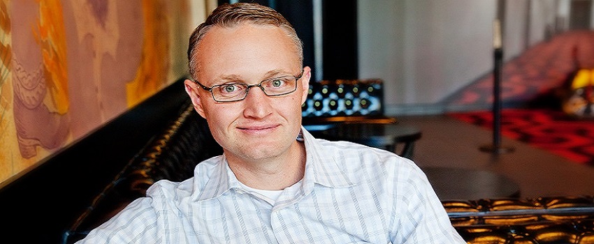 Garrett Martin, CEO of MileStone and Entrepreneur of the Year® Award finalist, sitting and smiling at camera.