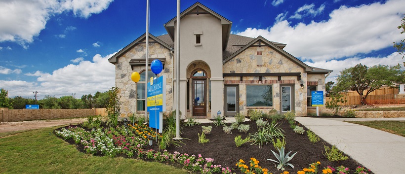 Stone and stucco front exterior of two-story home with landscaping and balloons.