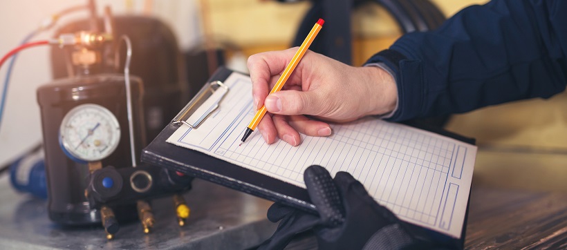 Close up of home inspector writing on paper with pen.