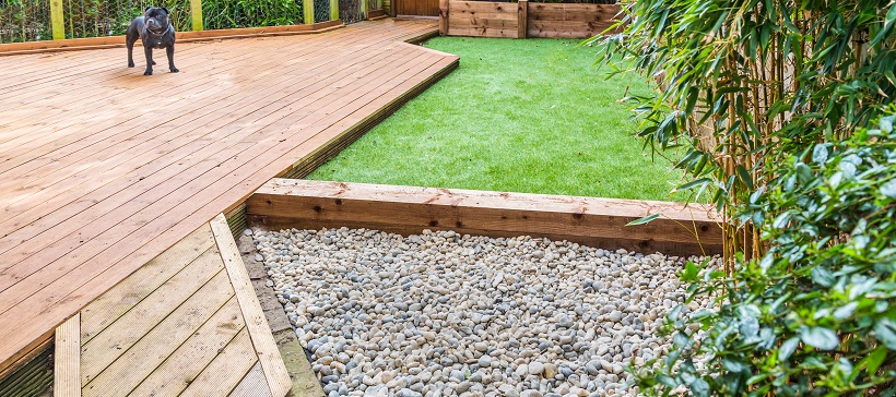 Gravel pathway and dog standing on wooden porch to show dog-friendly landscaping ideas.