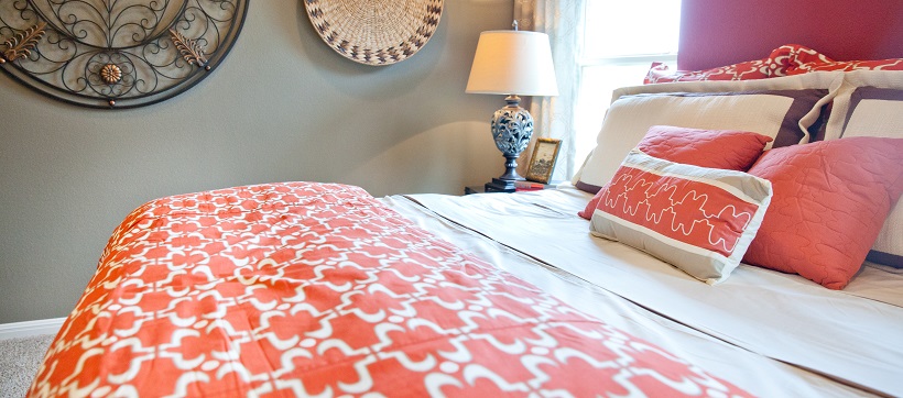 Close up of orange and white bedspread on bed at The Hills of Bear Creek.