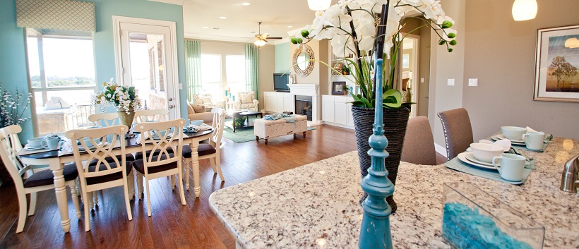 Sunlight shines through the light blue dining room, living room and kitchen of this open-concept home.