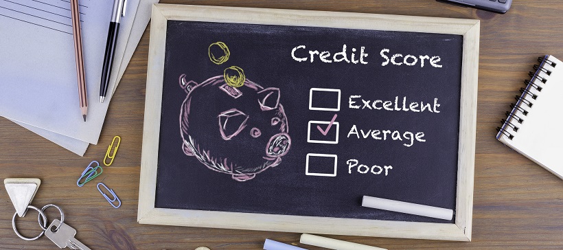 Desk with miscellaneous items and a chalkboard with the words “Credit Score” and options to check off, including “Excellent,” “Average,” and “Poor.”