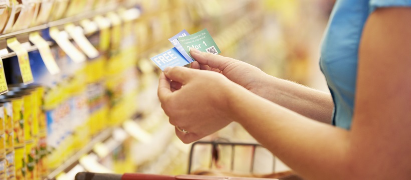 Close up of woman holding coupons while shopping at the grocery store