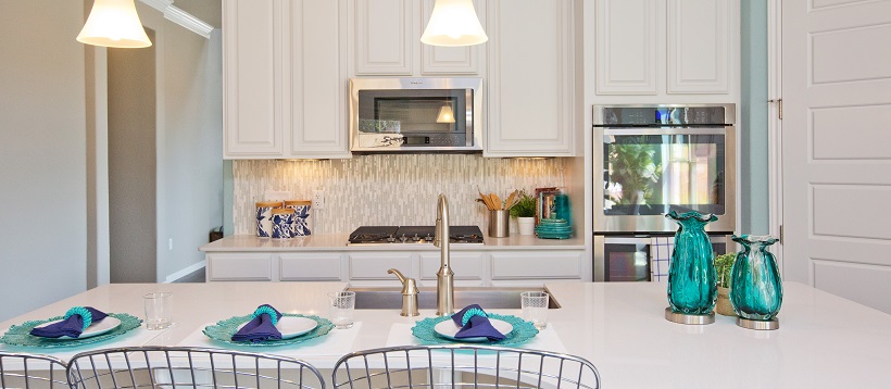 White home decor shown with white cabinets in a contemporary kitchen with blue accent pieces.