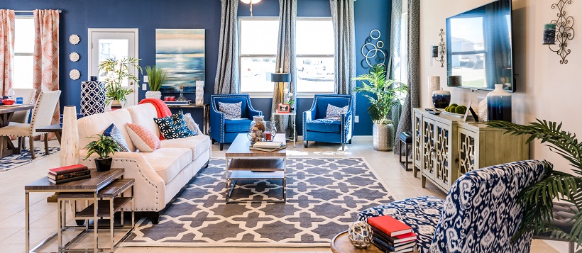 Vibrant living room with a white couch, blue accent wall, and various blue and white home decor pieces.