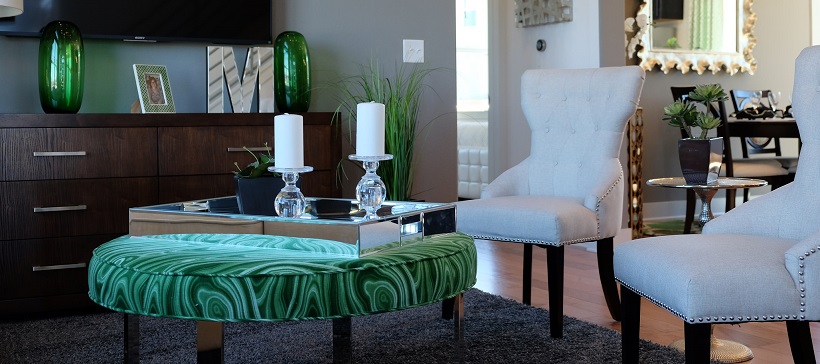 Living room seating area with white armchairs and a green ottoman.