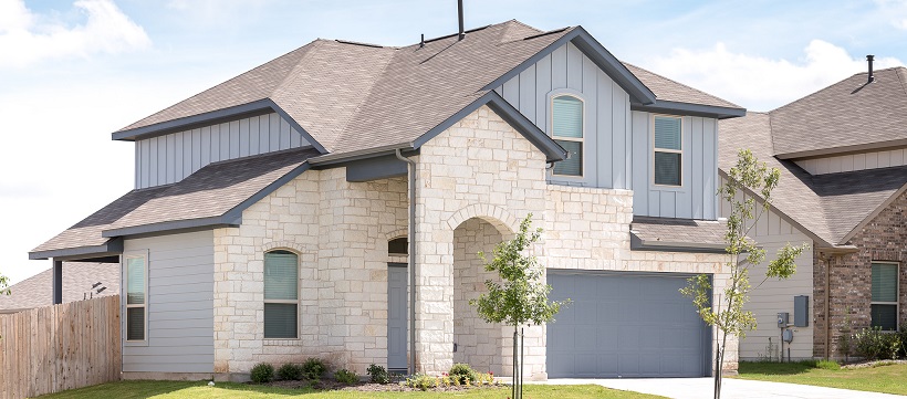 Two-story home with white stone and blue siding.