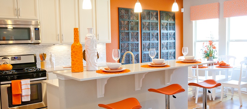 Modern kitchen with white cabinets and white home decor ideas as well as orange accents and stools.