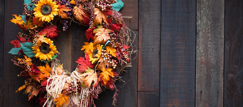 Colorful fall wreath against dark hardwood.
