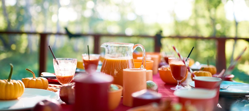 Outdoor table set up with fall décor in various shades of orange.