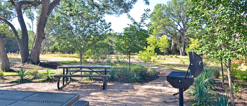 Picnic area with tables and trees near a MileStone community.