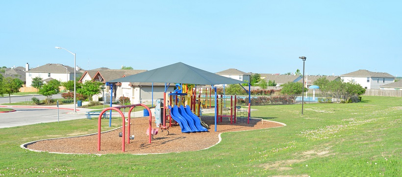 Shadow Creek’s playscape surrounded by lots of grass.